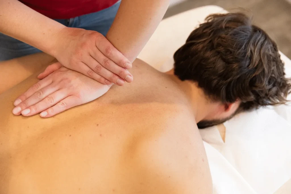 Physiotherapeutin massiert den Rücken eines Patienten – PhysioVital Hamburg-Bramfeld